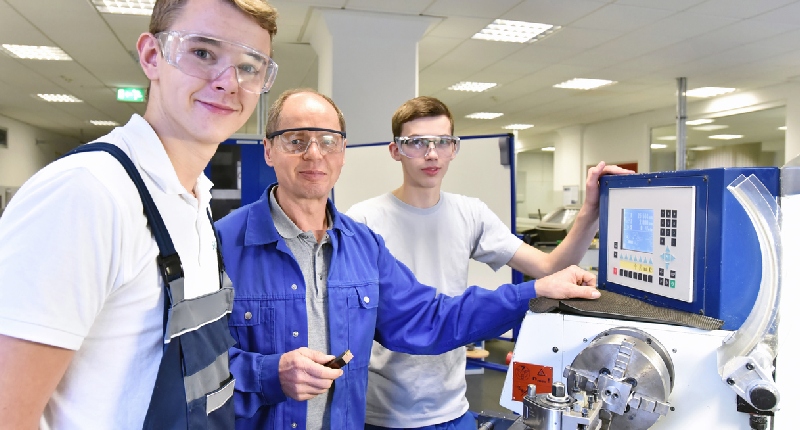 teacher using milling machine with students in classroom