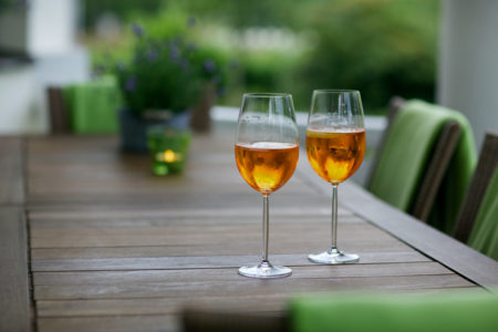 wooden table with wine glasses outside