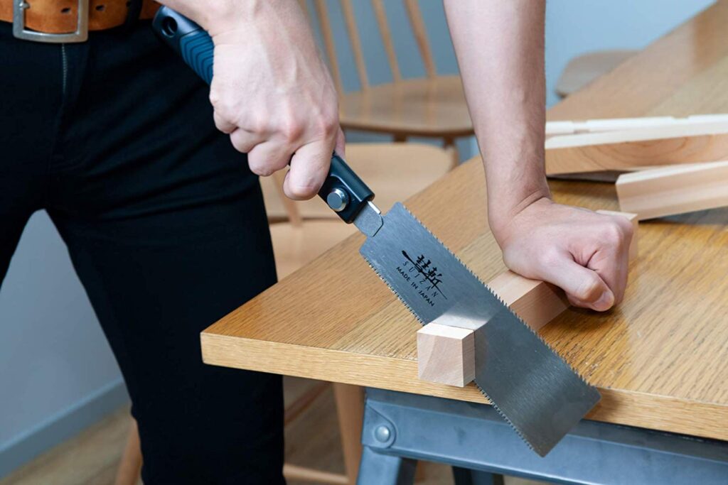 cutting a wood patch to repair rotten wood