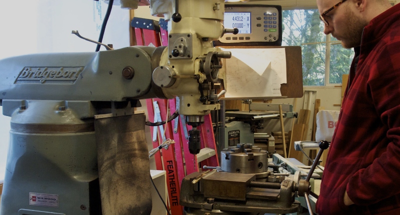 man using a bridgeport manual milling machine