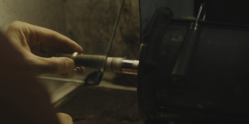 a jeweler polishing a gold ring on a machine