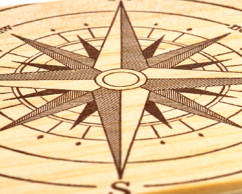 a piece of wood with an engraving of a compass